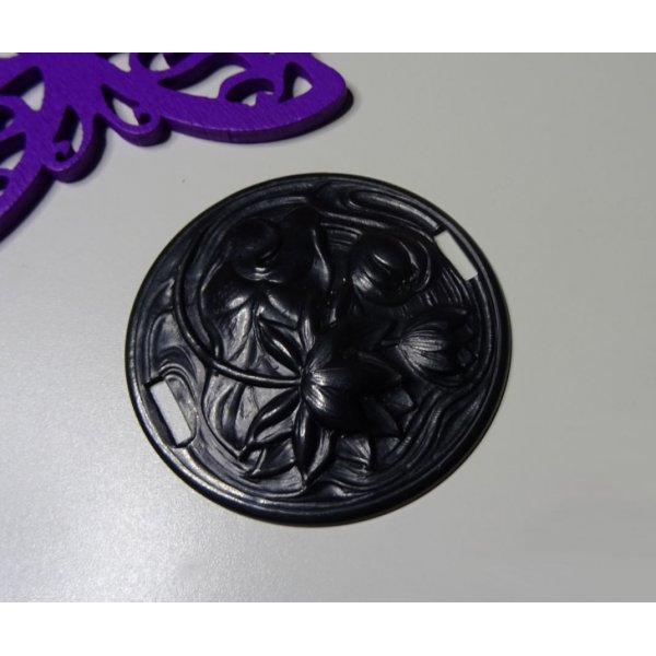 Medaglione a ninfea in metallo nero a rilievo con lacci laterali 